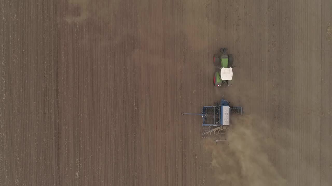 航拍两架拖拉机/农机具耕作/犁地。夏季干旱后马铃薯田干涸。视频下载