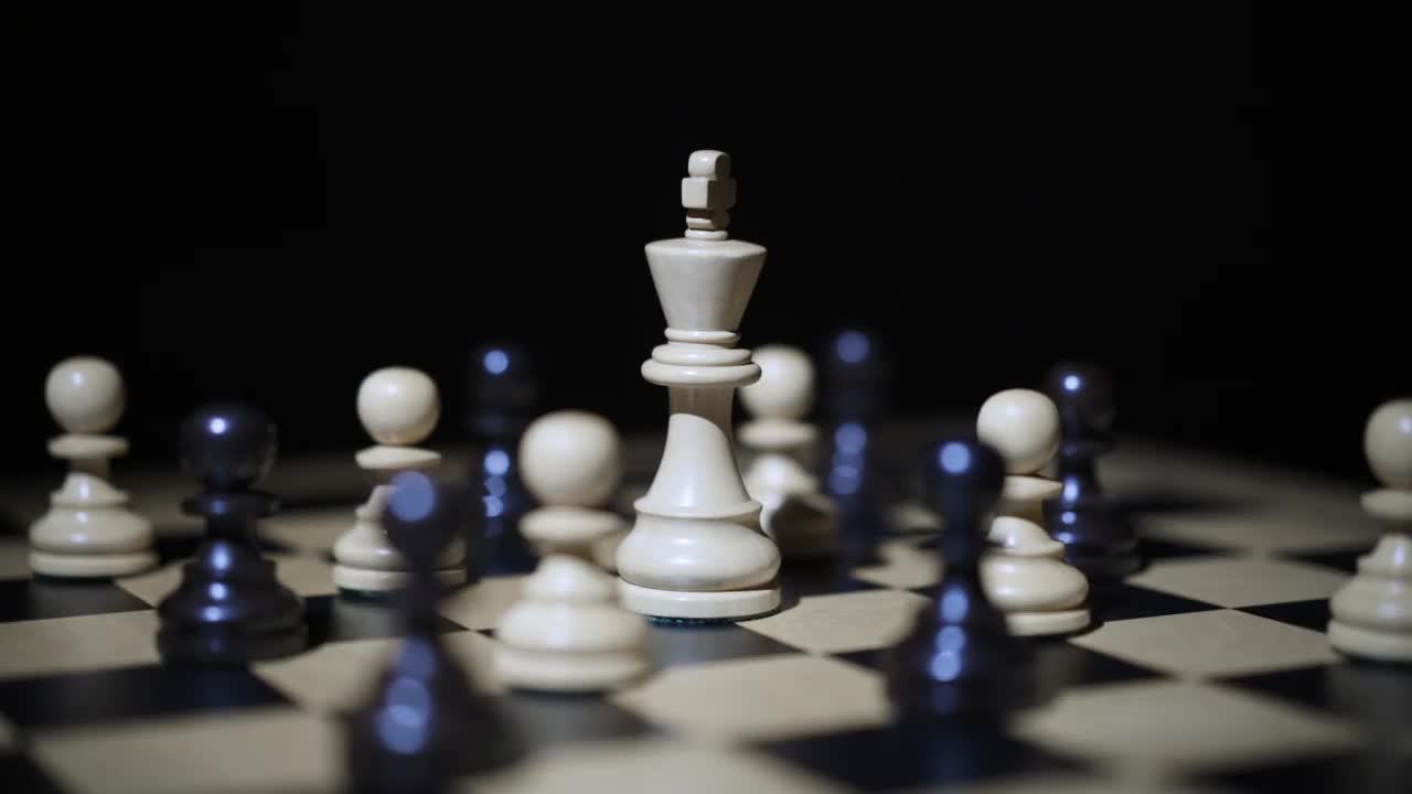 棋盘旋转。国王在中间。棋子被分配在棋盘上。白色和黑色的身影围绕着国王。视频下载