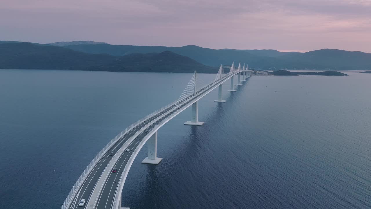俯瞰横跨地中海的雄伟大桥。汽车在桥上穿越蓝色的大海。视频素材