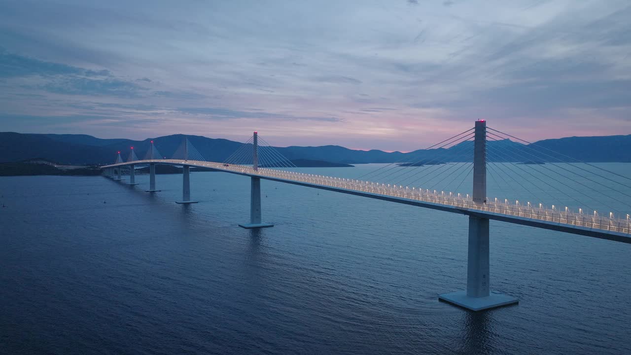 横跨地中海的现代桥梁。晚上过桥的汽车。深蓝色的大海和蓝色的天空。视频素材