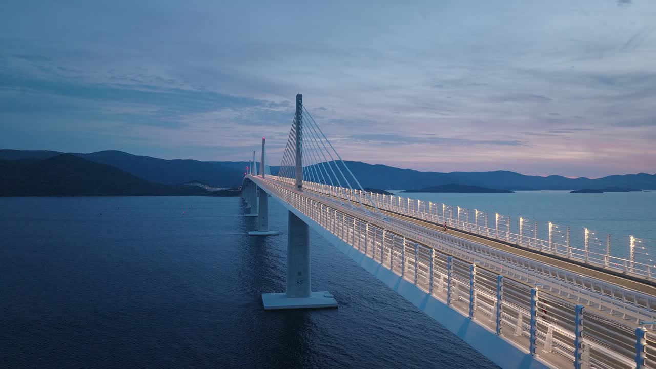 雄伟的大桥，灯火通明，晚上横跨地中海。连接陆地的长桥。运输的概念。视频素材