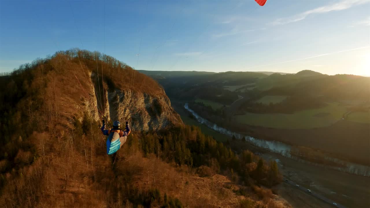 史诗般的滑翔伞飞行在岩石山脉在春天的自然在金色的日落视频下载