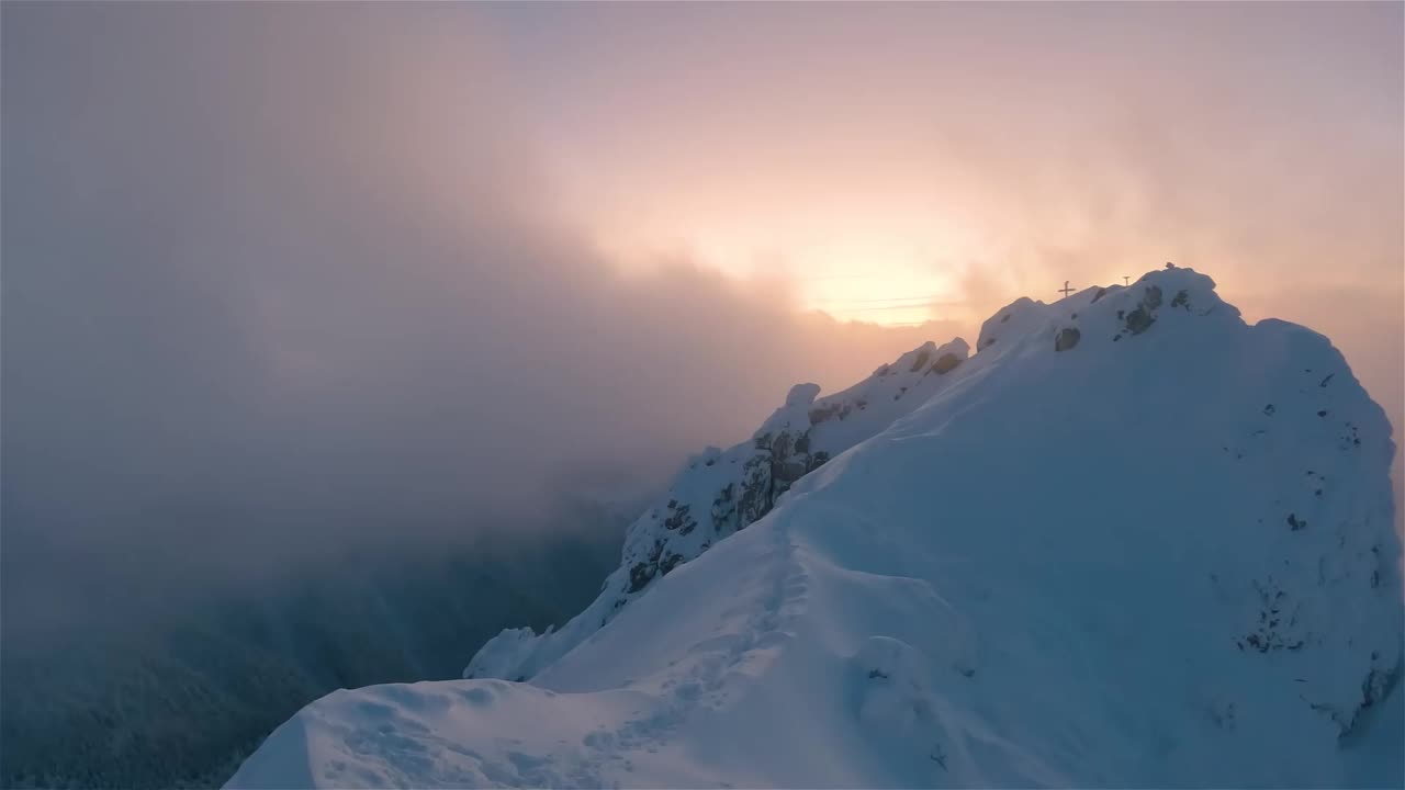 全景图:金色日出时，神秘的冬季山峰在白雪皑皑的阿尔卑斯山之巅视频下载