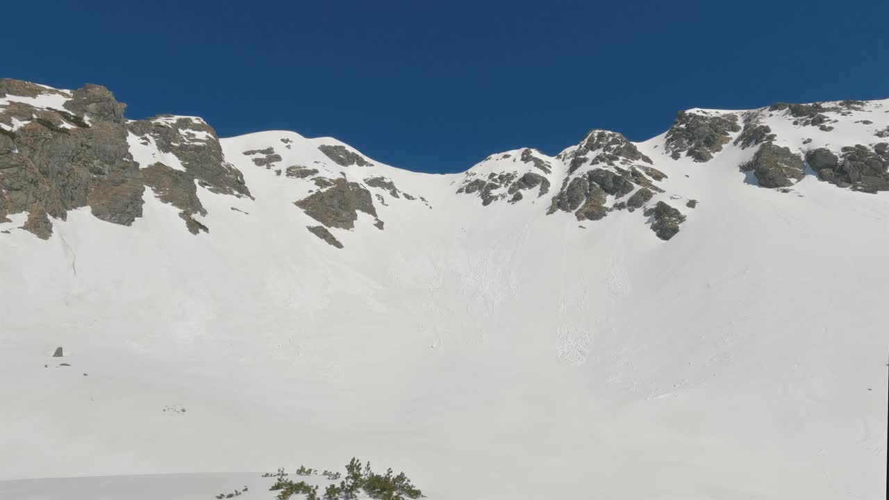 阳光明媚的冬季山脉的全景，在晴朗的日子里，在蓝天下的雪景中视频下载