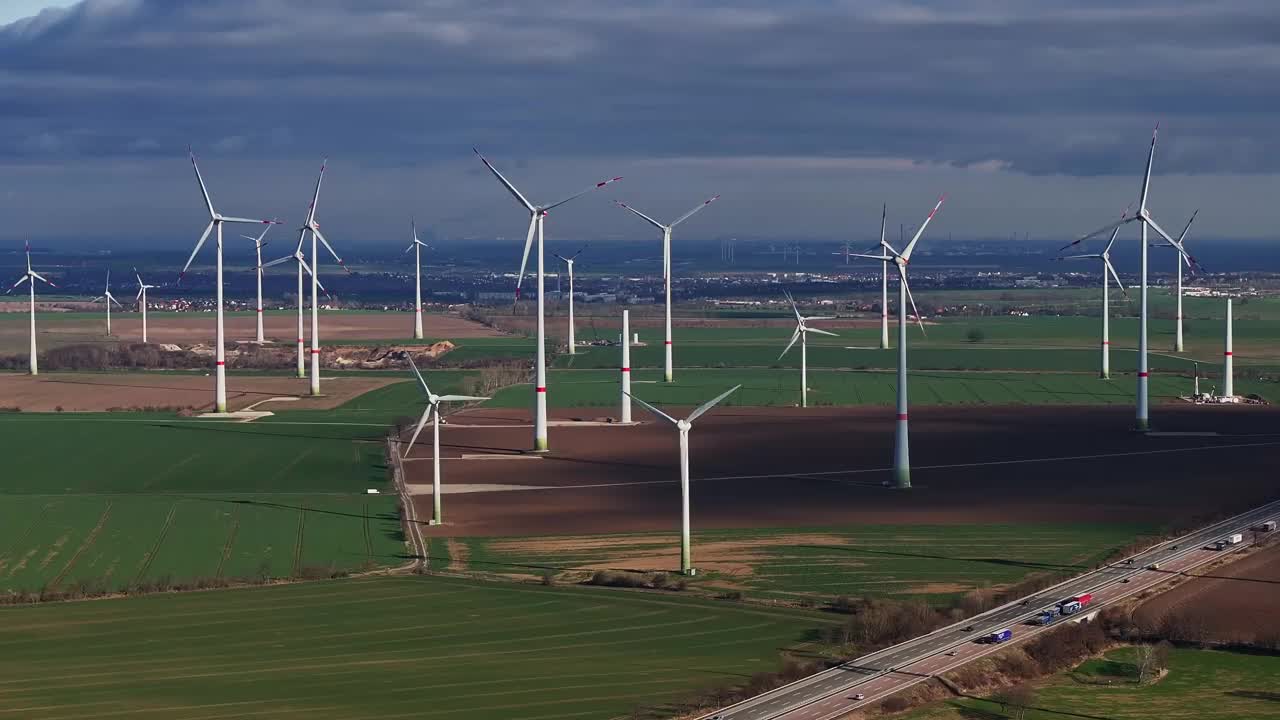 一个大型风电场的风力涡轮机的远摄照片。不同类型的风力涡轮机。下面是高速公路。新建风力涡轮机。视频下载
