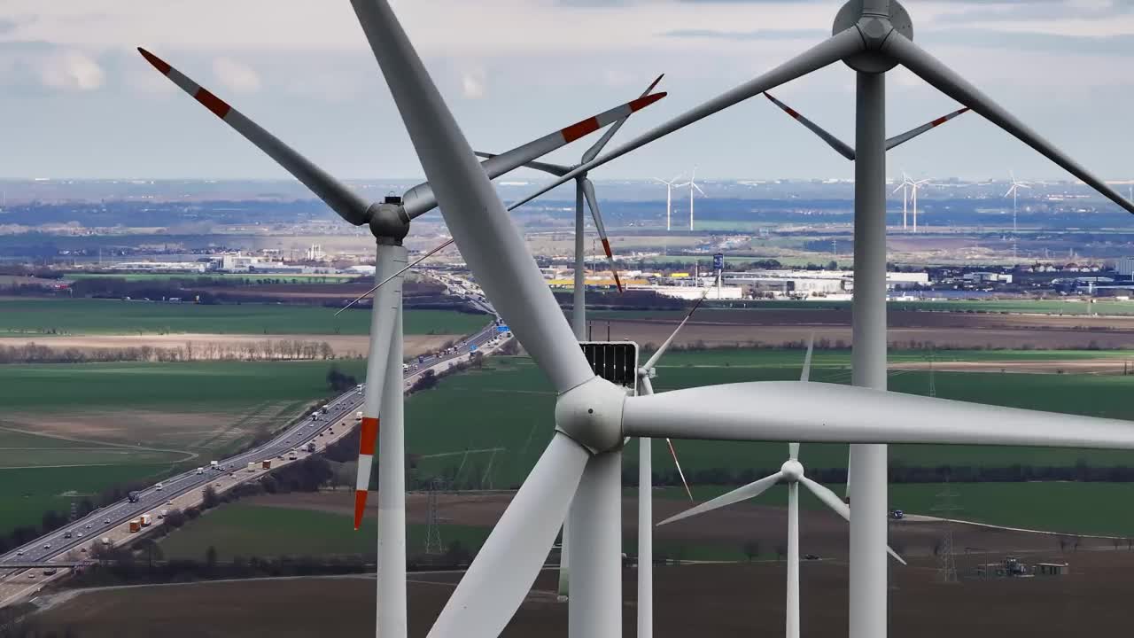 风力涡轮机的超长焦摄影。缓慢的飞行。背景是工业区。远处有一条高速公路。视频素材