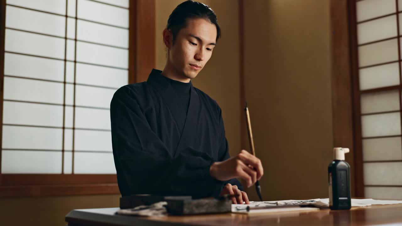 日本人，用毛笔书写，传统或古代的艺术工具，黑色的墨水和砚台。文字，字体和字母与创意和复古笔的书法和绘画视频下载