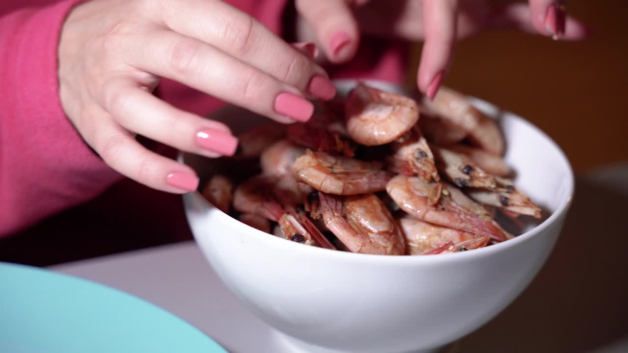 大虾。女性的手从盘子里拿起一只虾。视频下载