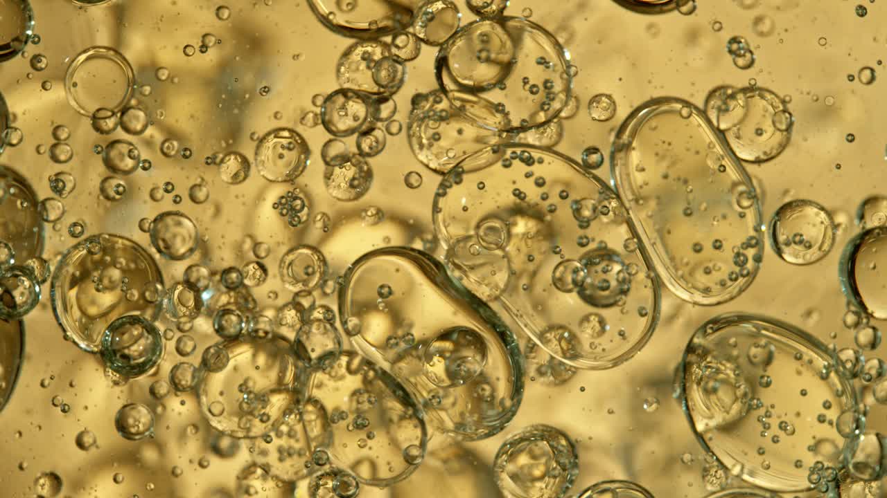 超级慢动作镜头移动油泡沫在金色背景，化妆品概念视频下载