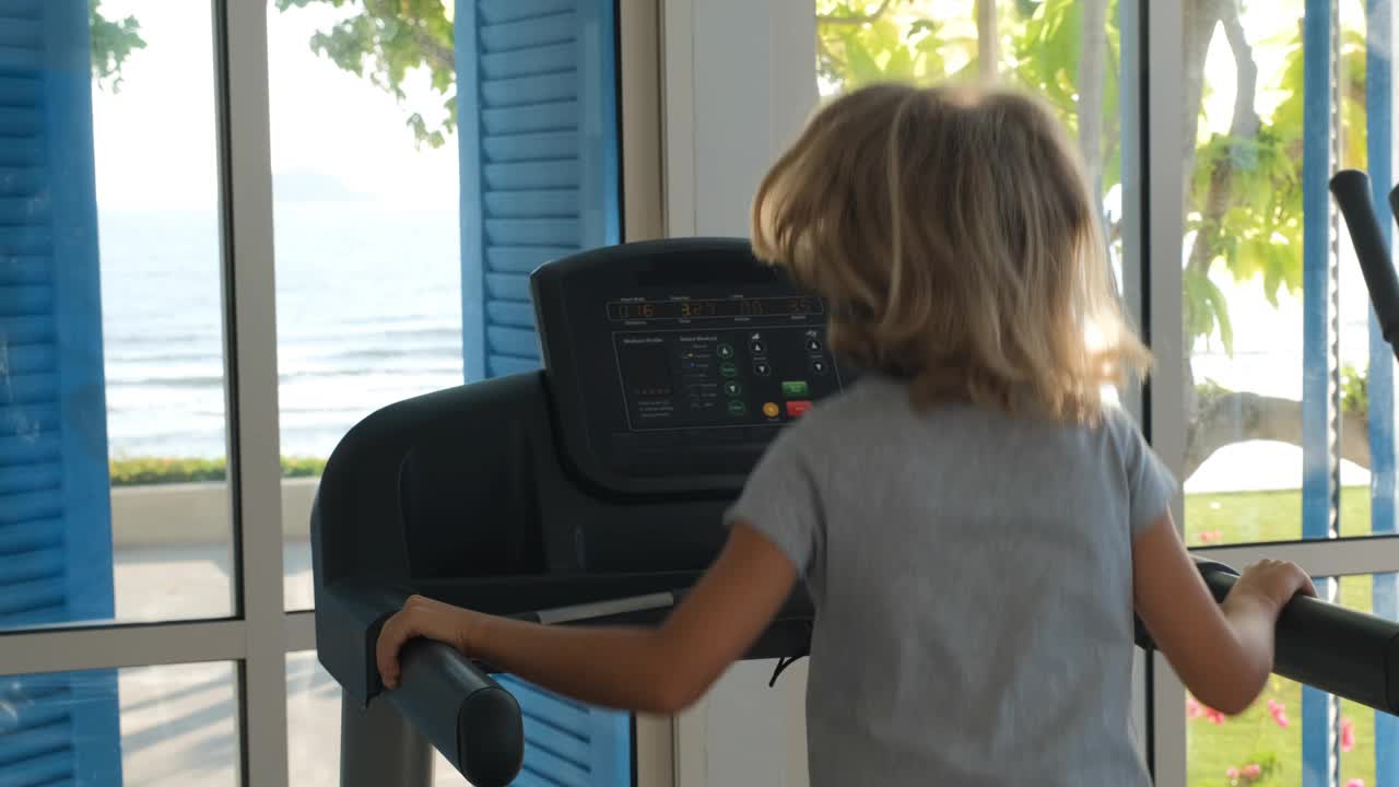 运动训练时在跑步机上慢跑的孩子视频下载