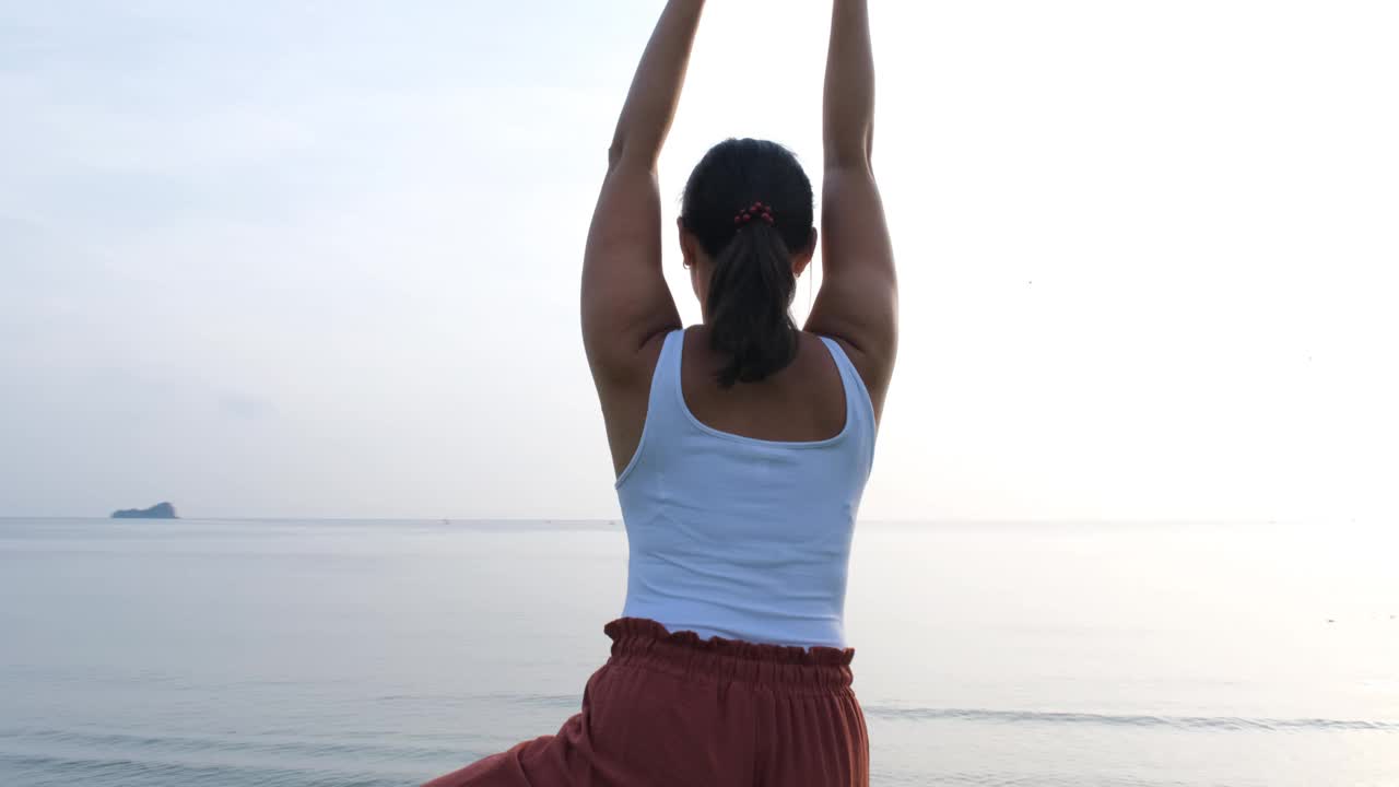 年轻女子练习海岸日出瑜伽视频下载