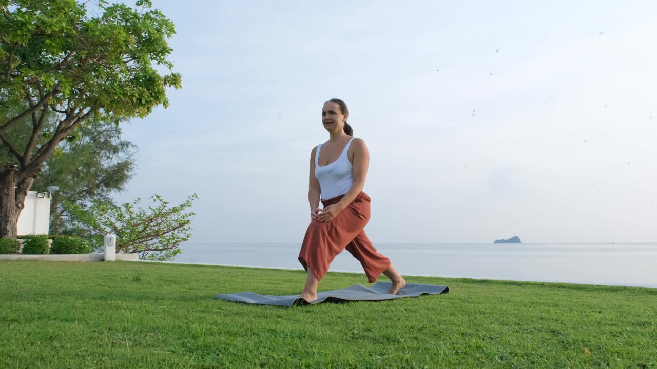 年轻女子在海边做的早晨瑜伽体式视频下载