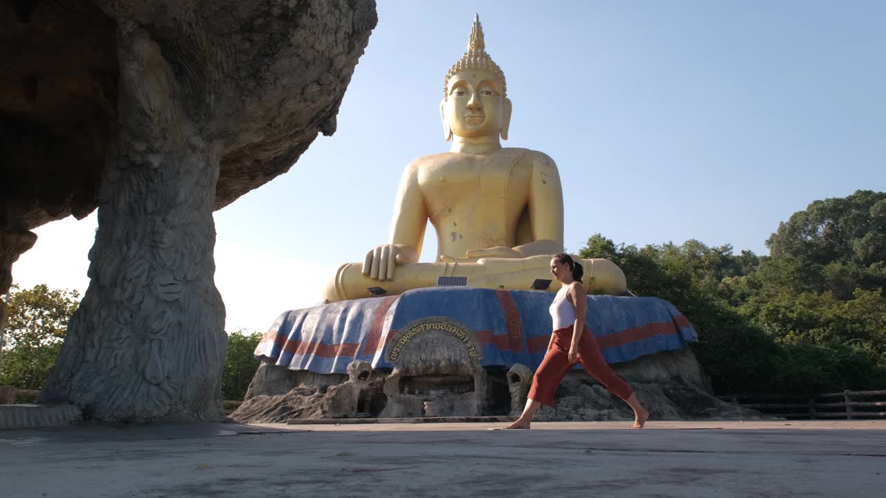 女子在佛像旁做早晨瑜伽视频下载