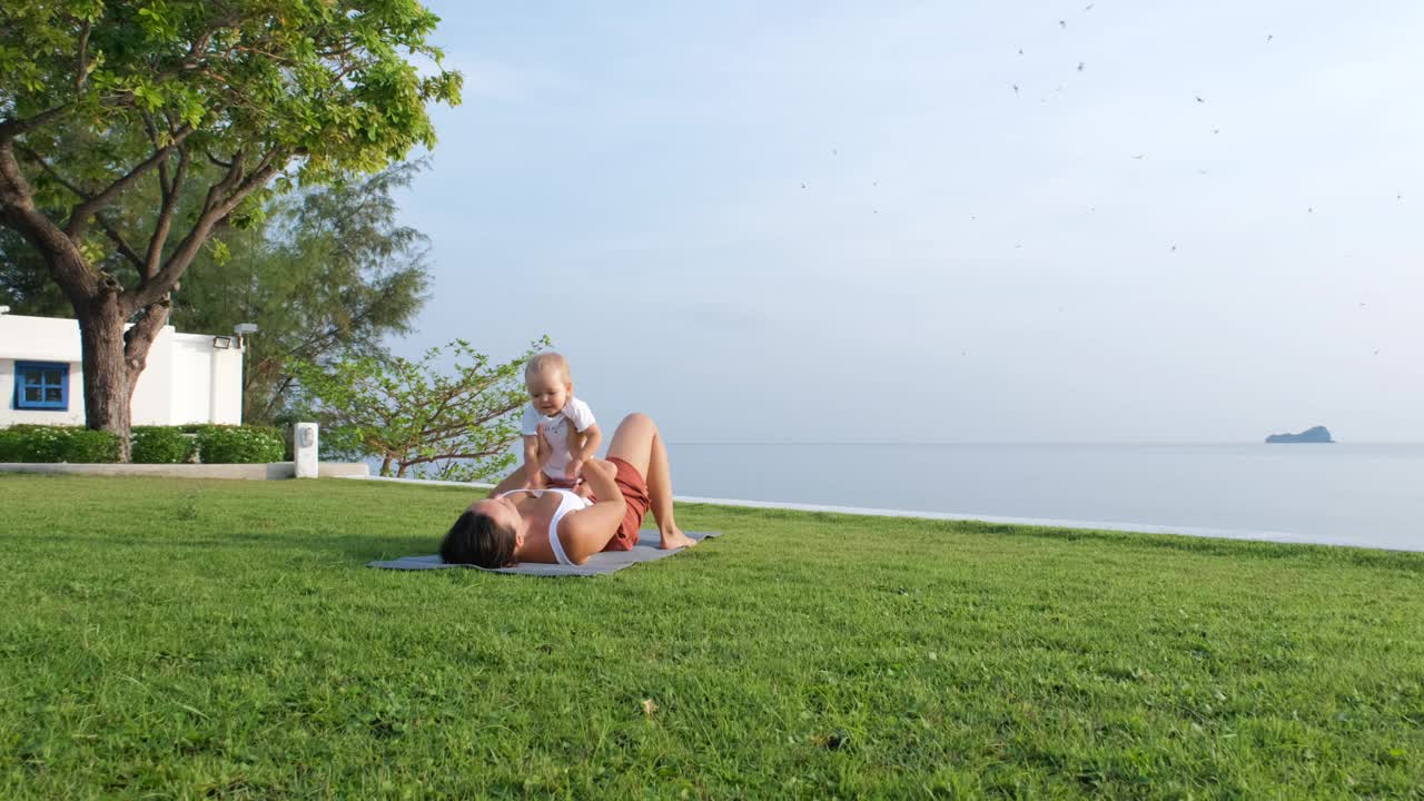 母亲带着孩子在海边享受瑜伽课程视频下载