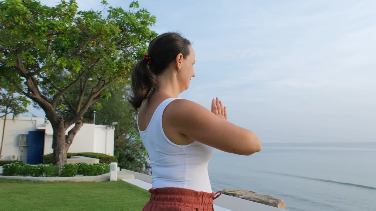 海边日出瑜伽练习的年轻女子视频下载