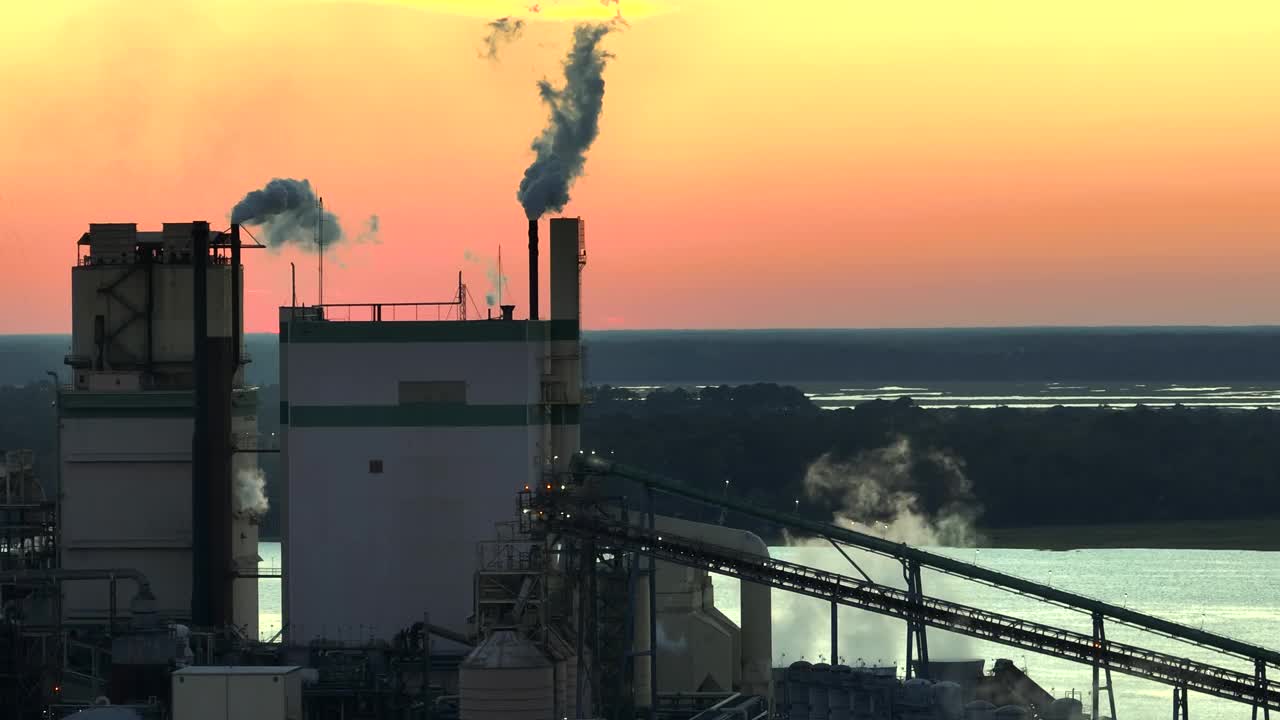 大型工厂鸟瞰图，生产过程中的烟囱污染了工厂制造场的大气。夕阳下的工业用地视频下载