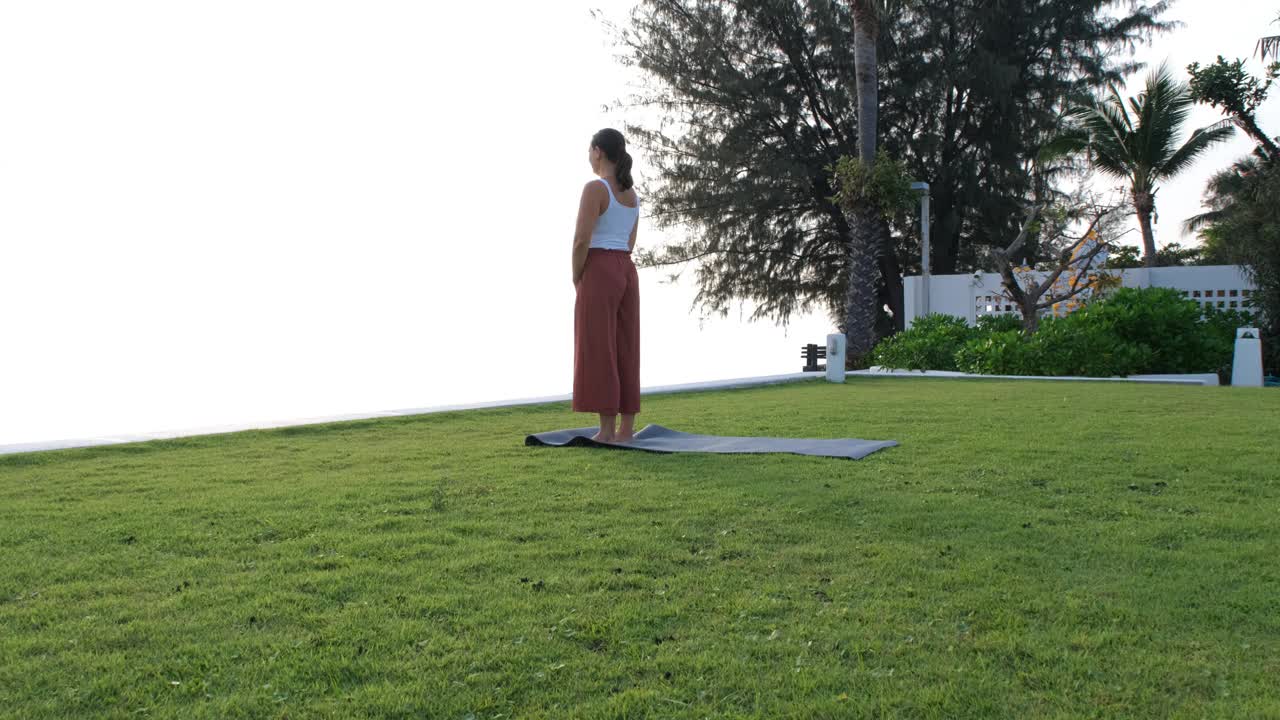 一名妇女在海边做瑜伽练习视频下载