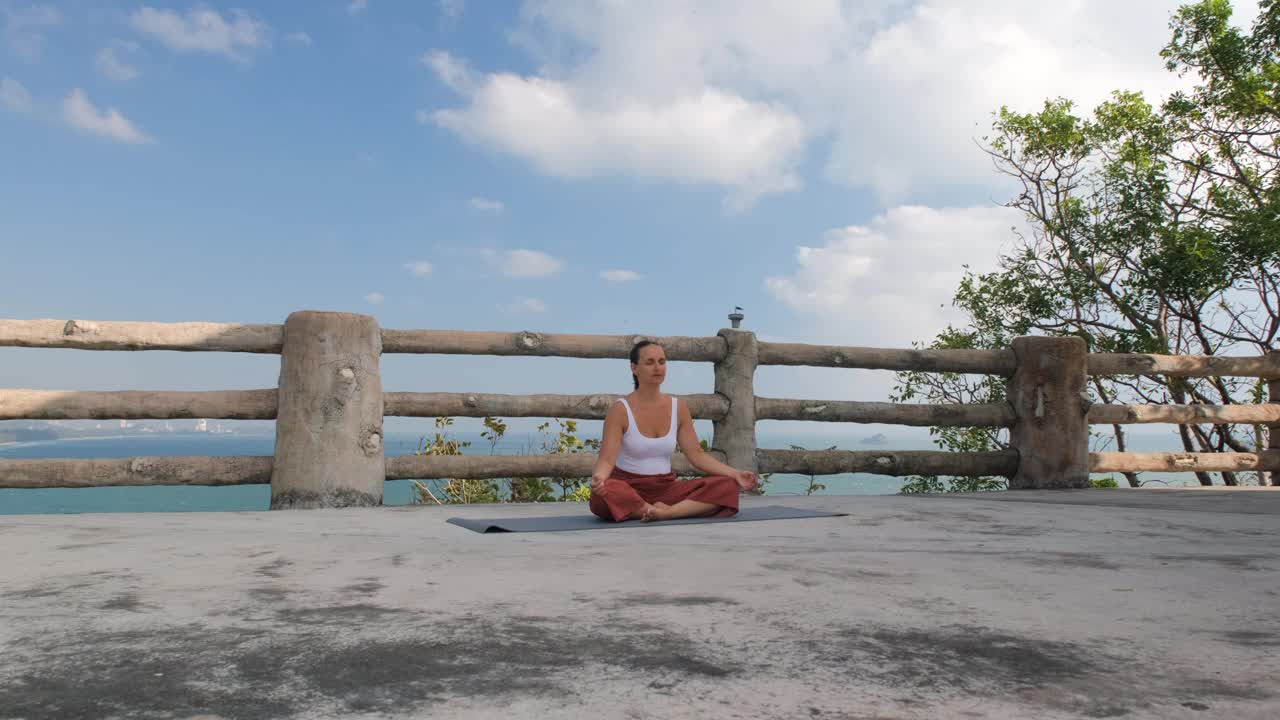 海边地平线上年轻女子的瑜伽静修视频下载