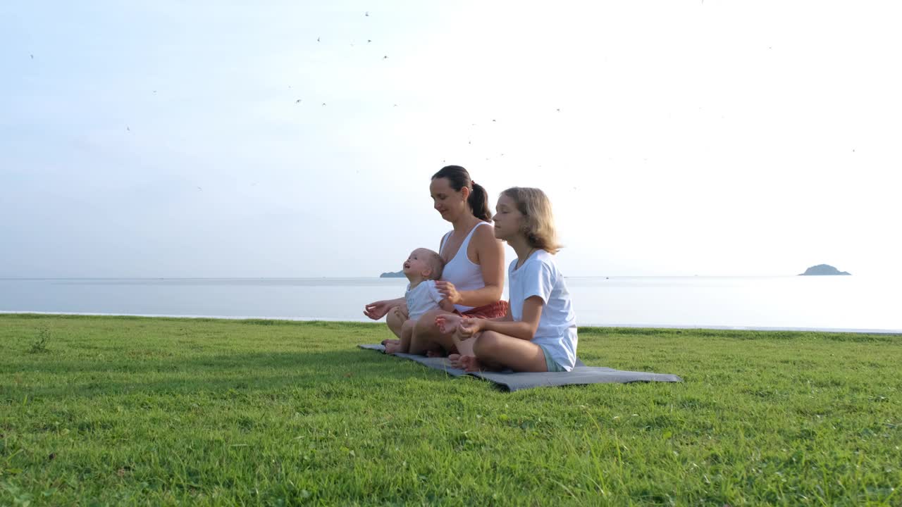 母亲和孩子在海边做瑜伽视频下载
