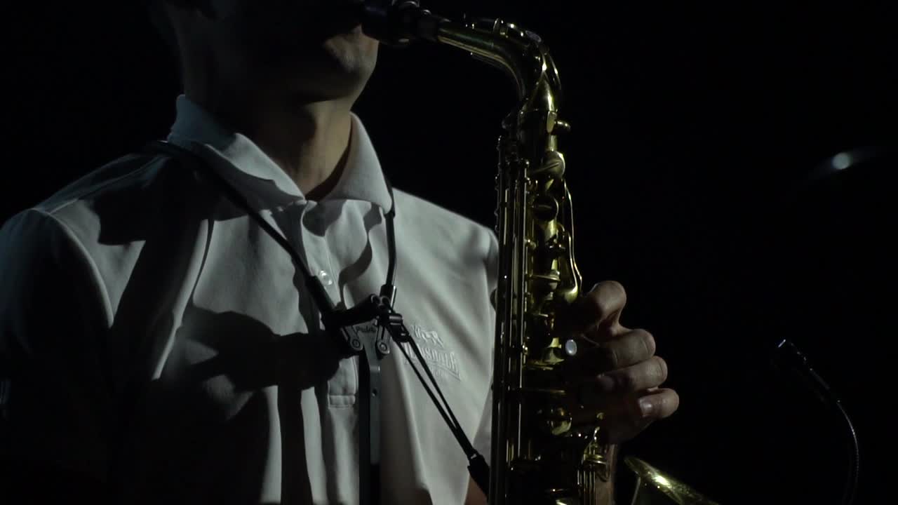 萨克斯管的特写，一个男人在演奏，戏剧性的灯光视频下载