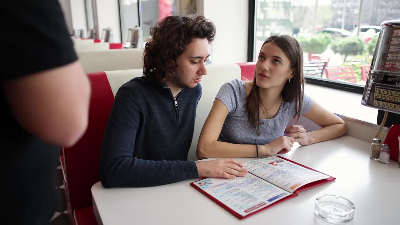 一对年轻夫妇，在一家复古快餐店向服务员点餐视频下载