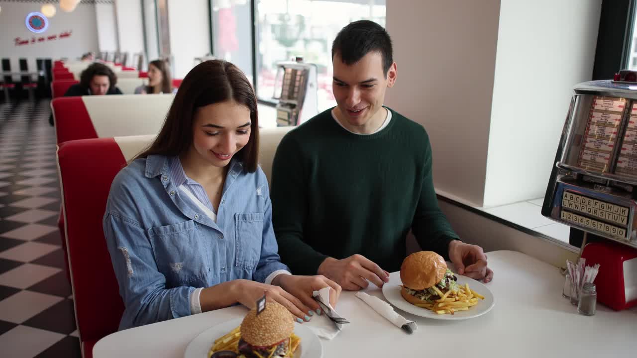 年轻夫妇在复古餐厅吃汉堡视频下载