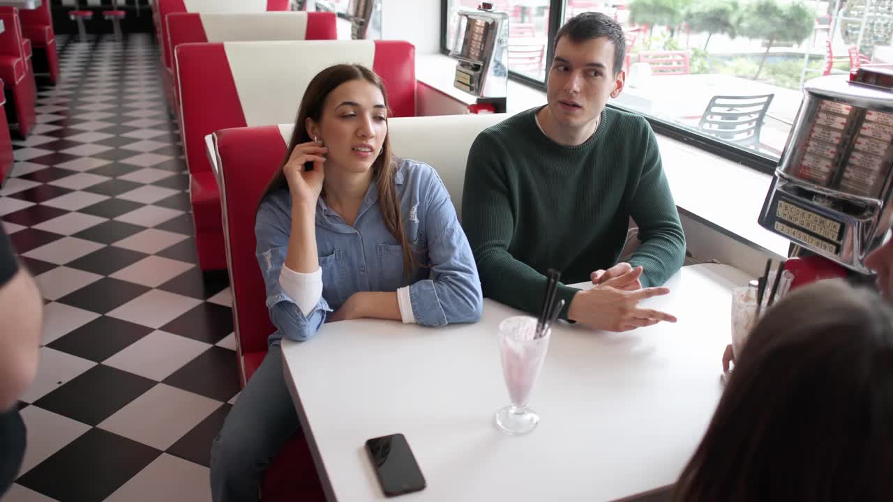 年轻的白种人在复古的快餐店进行四人约会视频下载
