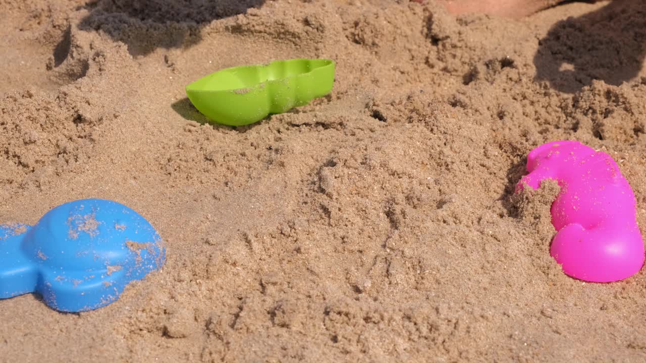 小女孩在沙滩上玩沙子的特写视频下载