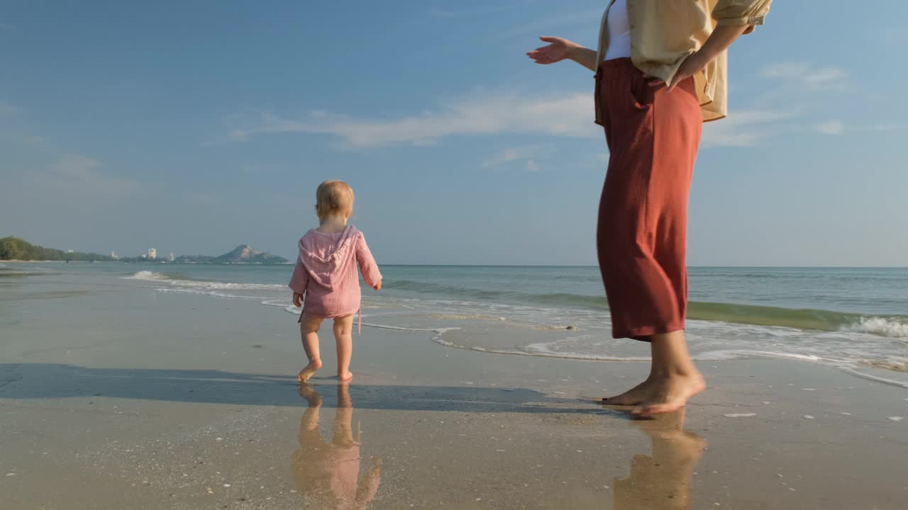 可爱的宝宝和妈妈在海边散步视频下载