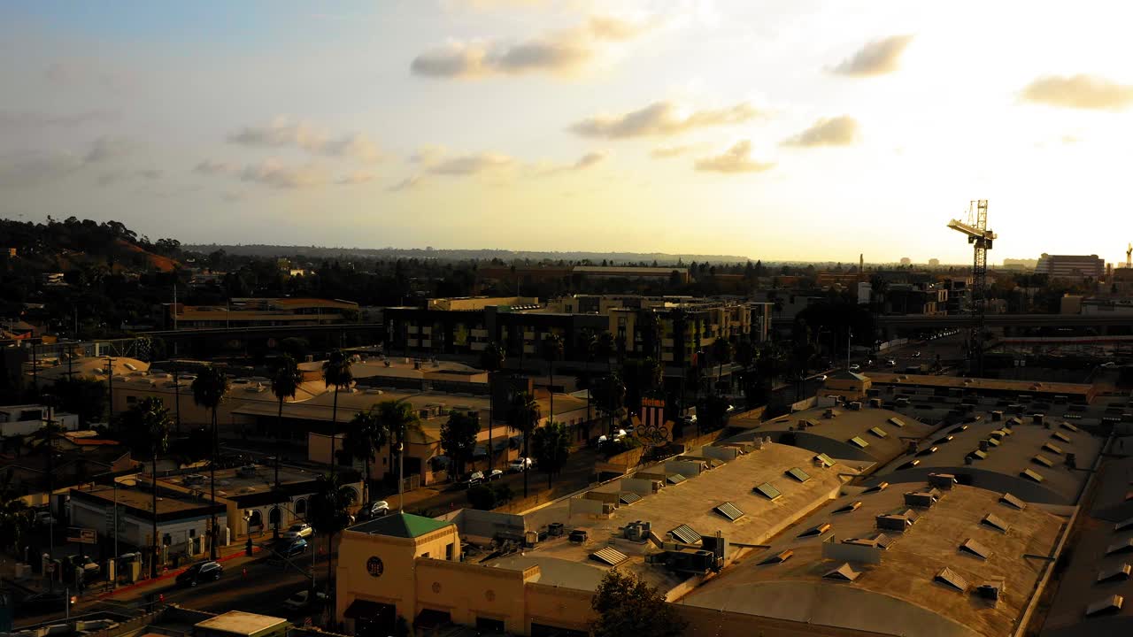 在日落期间，加利福尼亚州卡尔弗城，在住宅城市顶部的赫尔姆斯面包店的空中下降放大镜头视频下载