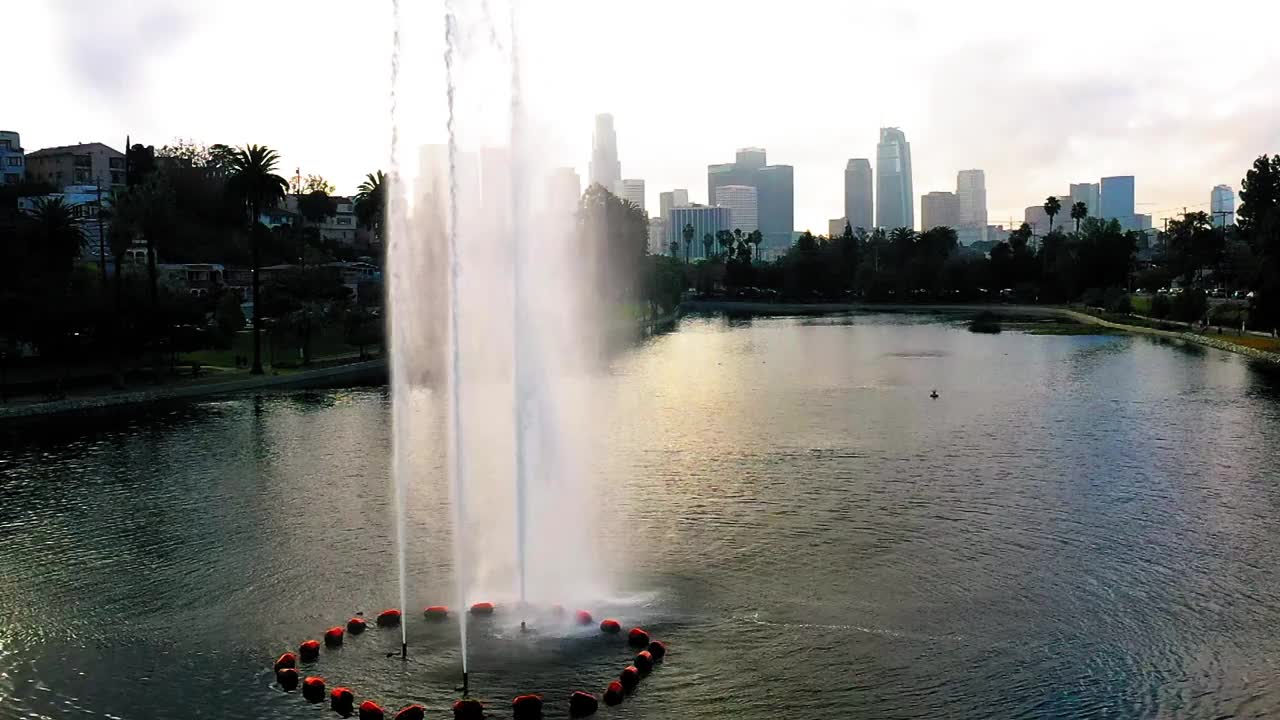 航拍:慢动作美丽的湖在著名的公园由现代建筑，无人机在湖上飞行向上-洛杉矶，加利福尼亚视频下载