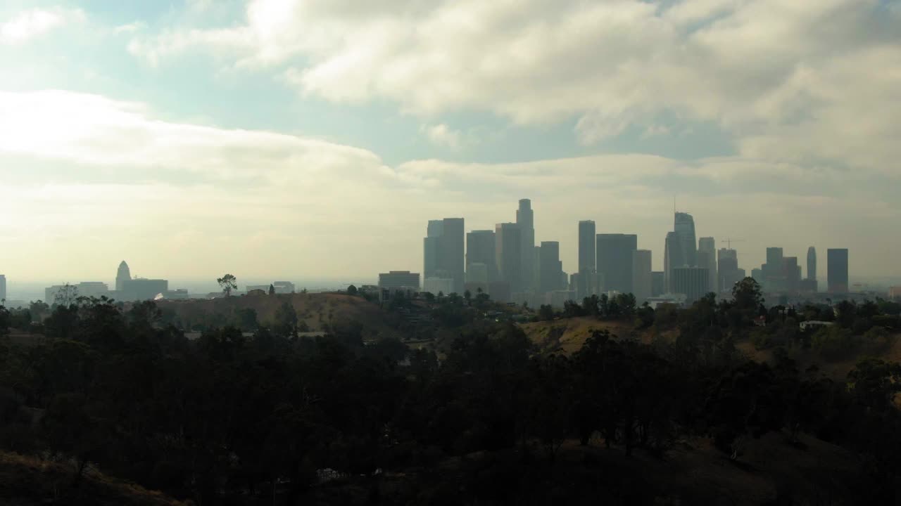 在多云的天空下，洛杉矶，加利福尼亚，在现代城市的宁静的山丘上，航拍缩小市区视频下载