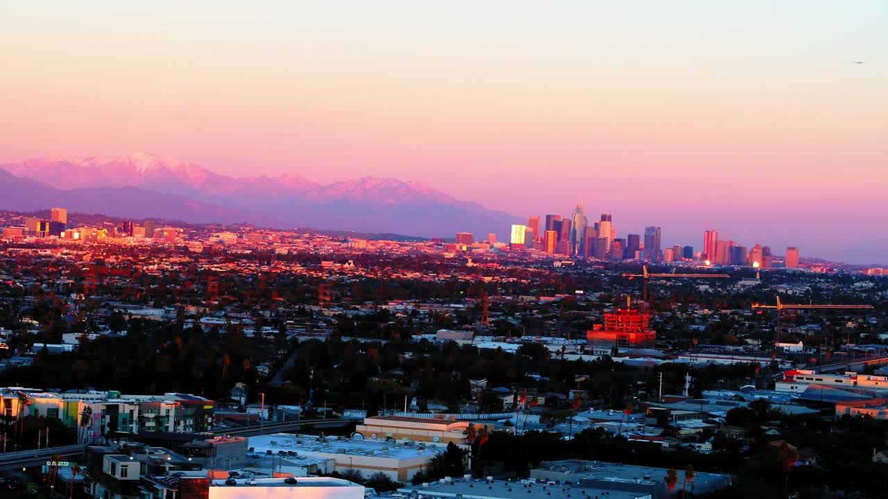 空中平移拍摄的金融区在住宅城市山对戏剧性的晴空-洛杉矶，加利福尼亚视频下载