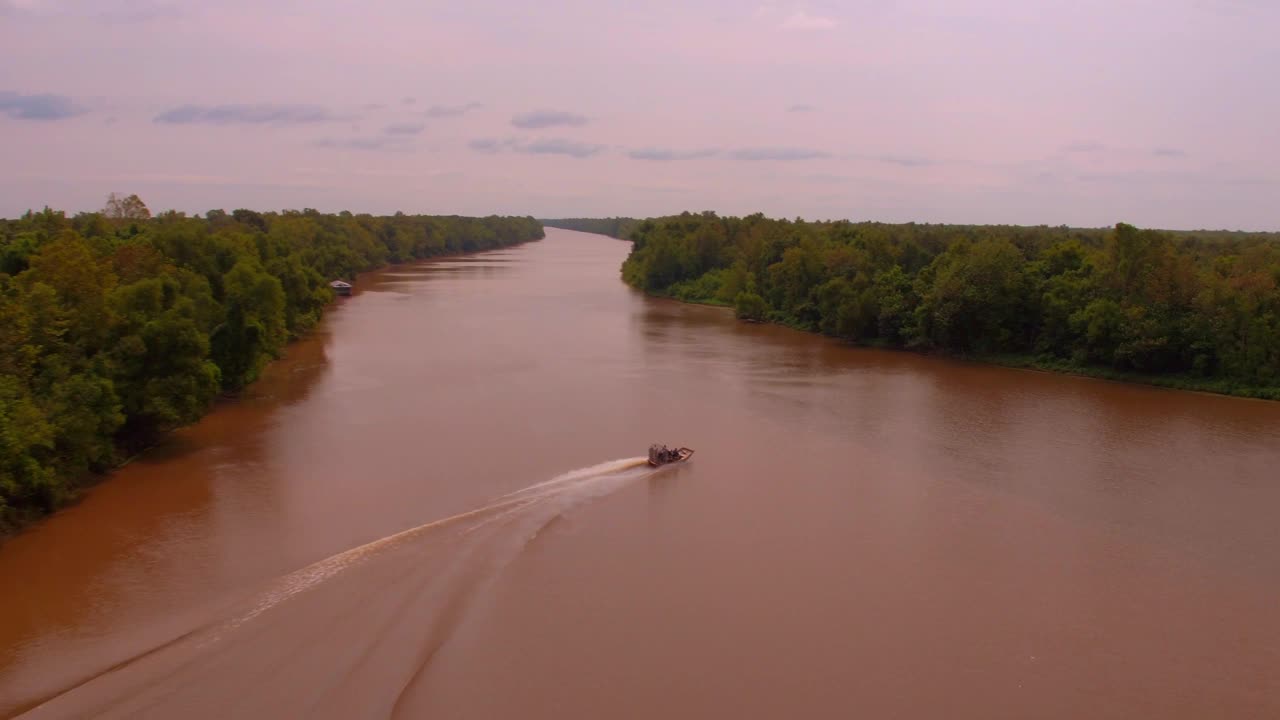 航拍拍摄的摩托艇移动的波纹河溪在绿色森林- Bayou Vista，德克萨斯州视频下载