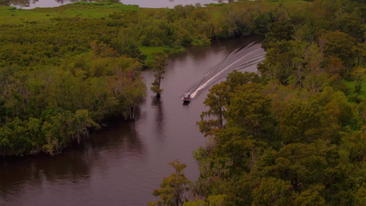航拍的向后风景的摩托艇移动的河溪在绿色森林- Bayou Vista，德克萨斯州视频下载