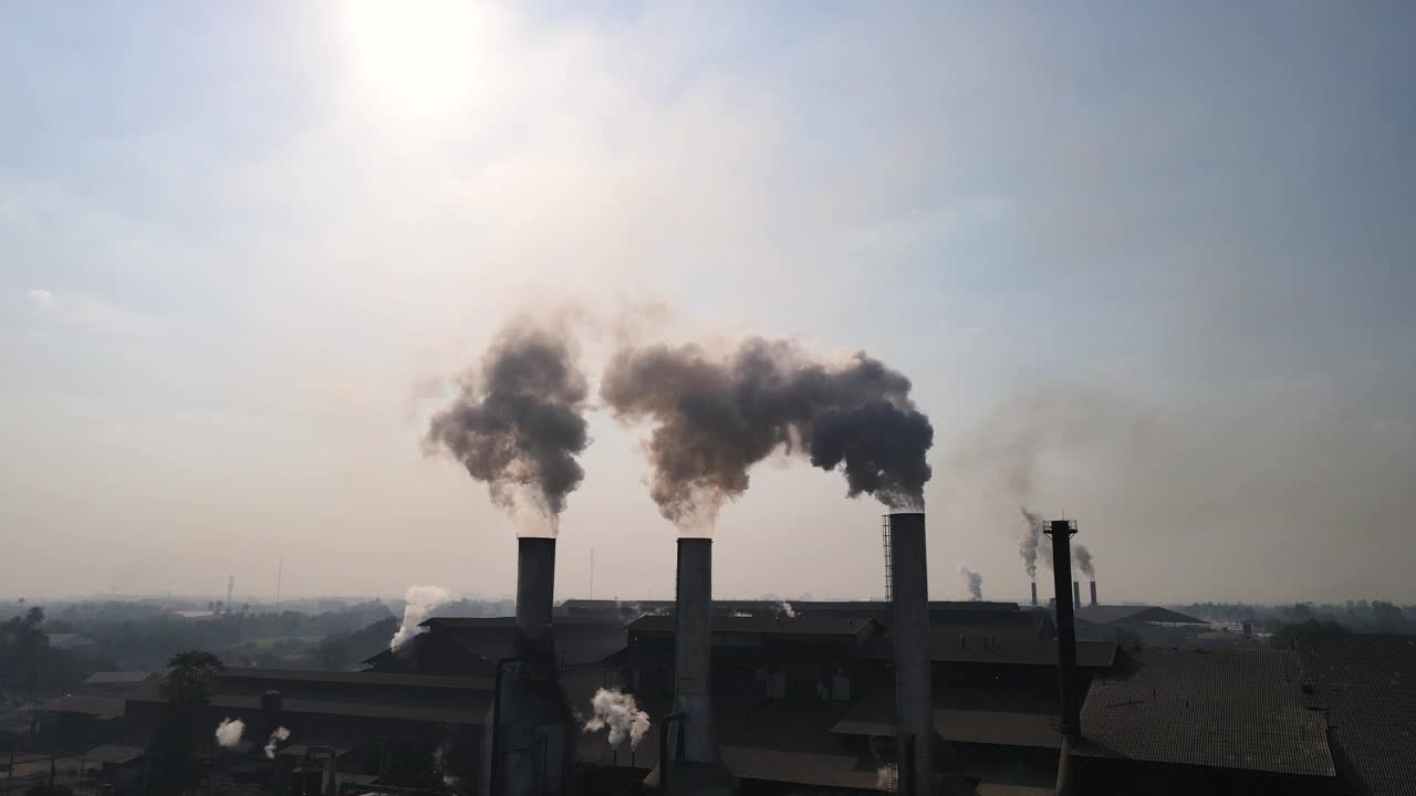 日出时工厂烟囱冒出的烟雾鸟瞰图视频下载