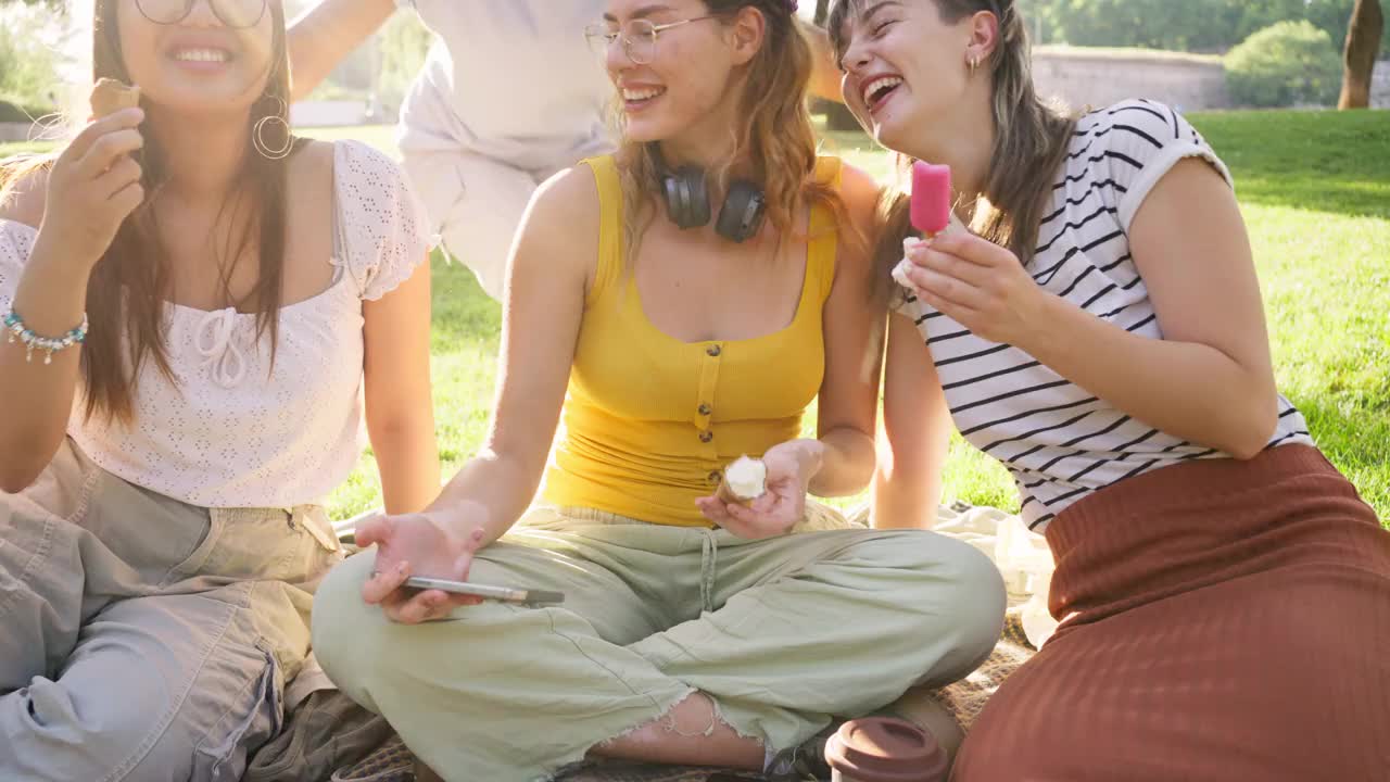 一群多种族的女性朋友在野餐时一边吃冰淇淋一边自拍视频下载