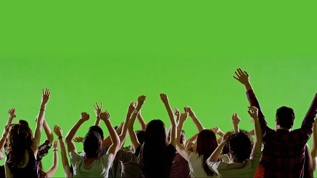 一群粉絲在綠色屏幕上跳舞。音樂會,跳跳舞。緩慢的運動。用紅色史詩電影攝像機拍攝。視頻素材