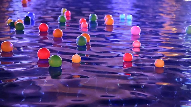 游泳池中漂浮的彩色球视频素材