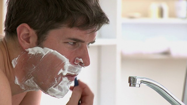 帅哥在浴室里刮胡子视频素材