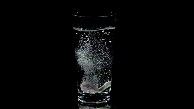 HD SLOW:维生素片落入玻璃水中溶解视频素材