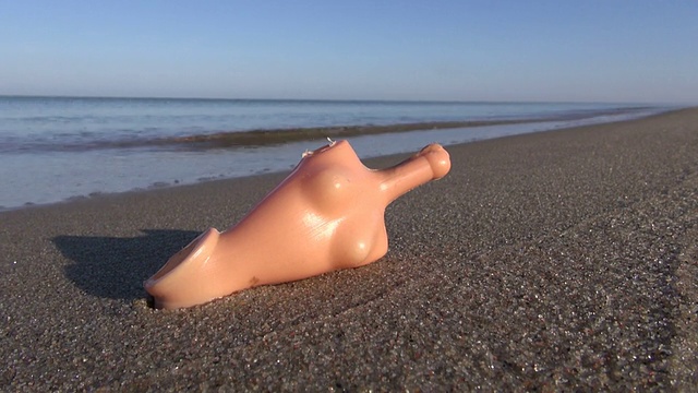 沙滩上的旧塑料娃娃躯干视频下载