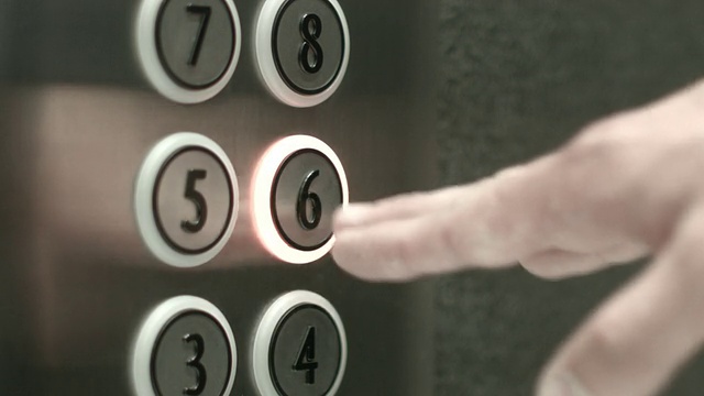 一名男子在电梯里按下了六楼的按钮视频素材