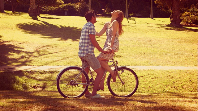 一对可爱的情侣在公园里骑自行车视频下载