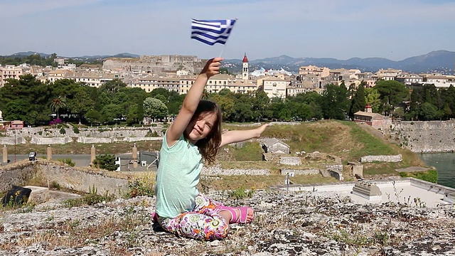 快乐的小女孩挥舞着希腊科孚镇的国旗视频素材