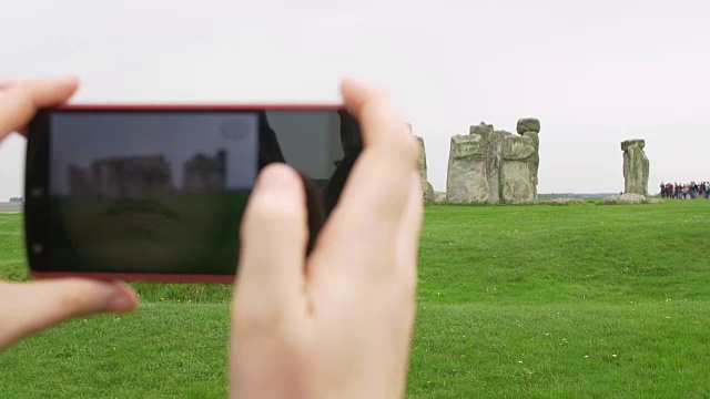 一名女子手持智能手机向巨石阵拍照视频素材