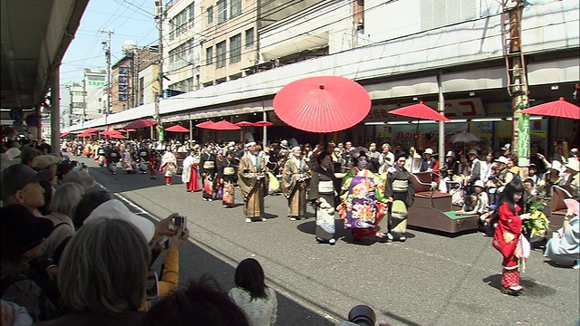 在日本下关赤间神社前，身着传统宫廷服装的妇女们在街道上游行。视频下载