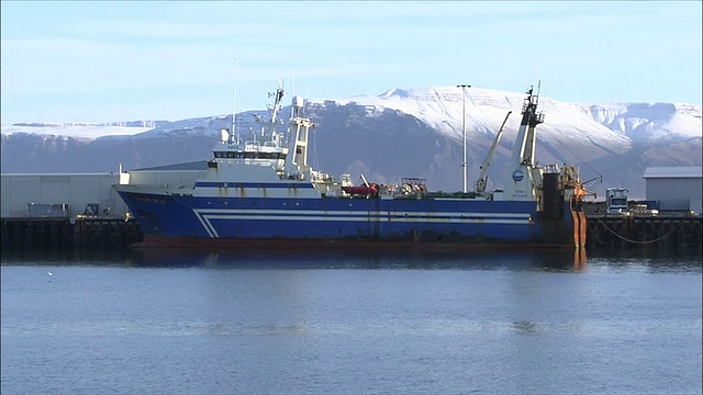 在冰岛雷克雅未克雪山附近的一个渔港，船只排成一行。视频素材