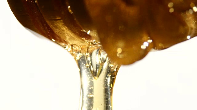 蜂蜜从木勺上滴下来，上白，近处，阴影视频下载
