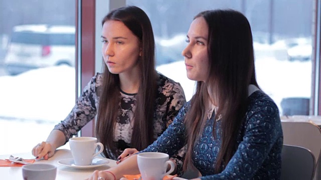 两个面带微笑的女朋友一边喝咖啡一边交流视频下载
